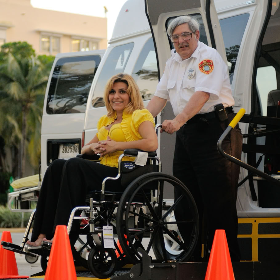 A transport service assisting a person in a wheelchair outdoors, focusing on accessibility.