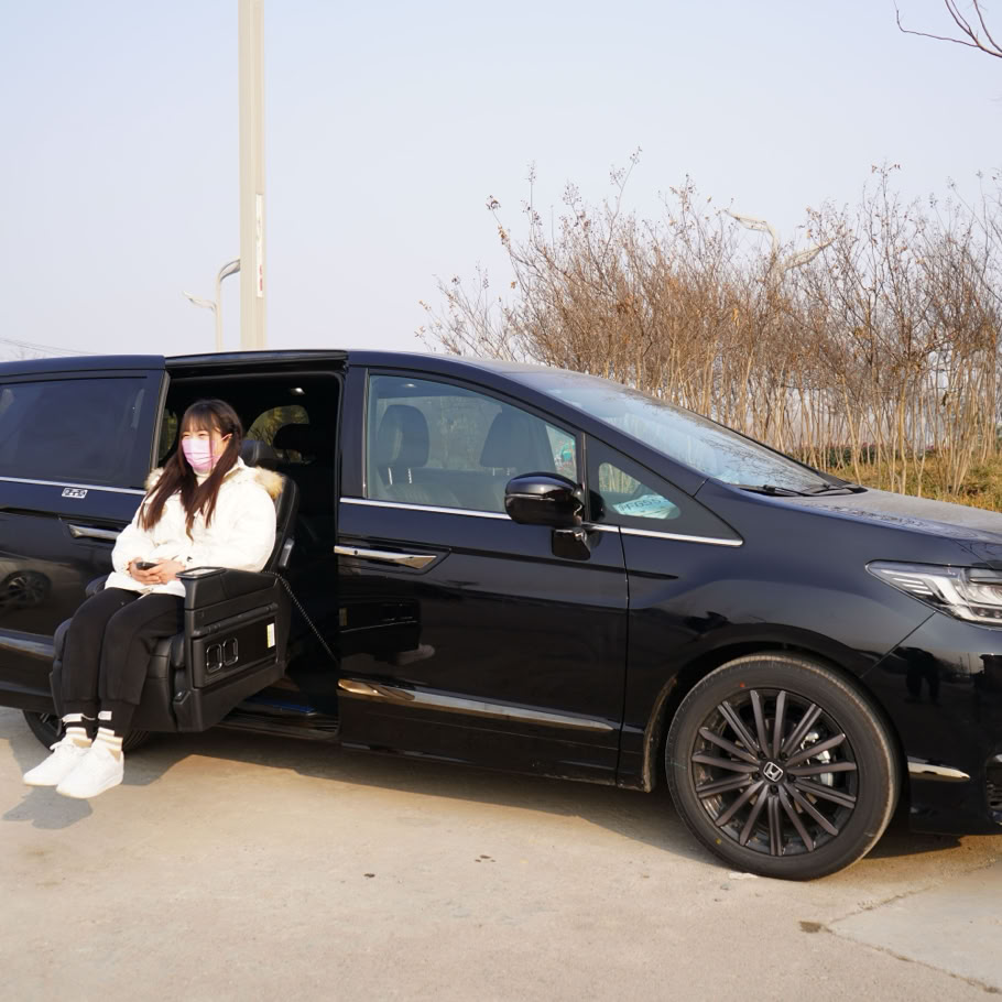 Woman in face mask using sliding seat in black car with nearby wheelchair.